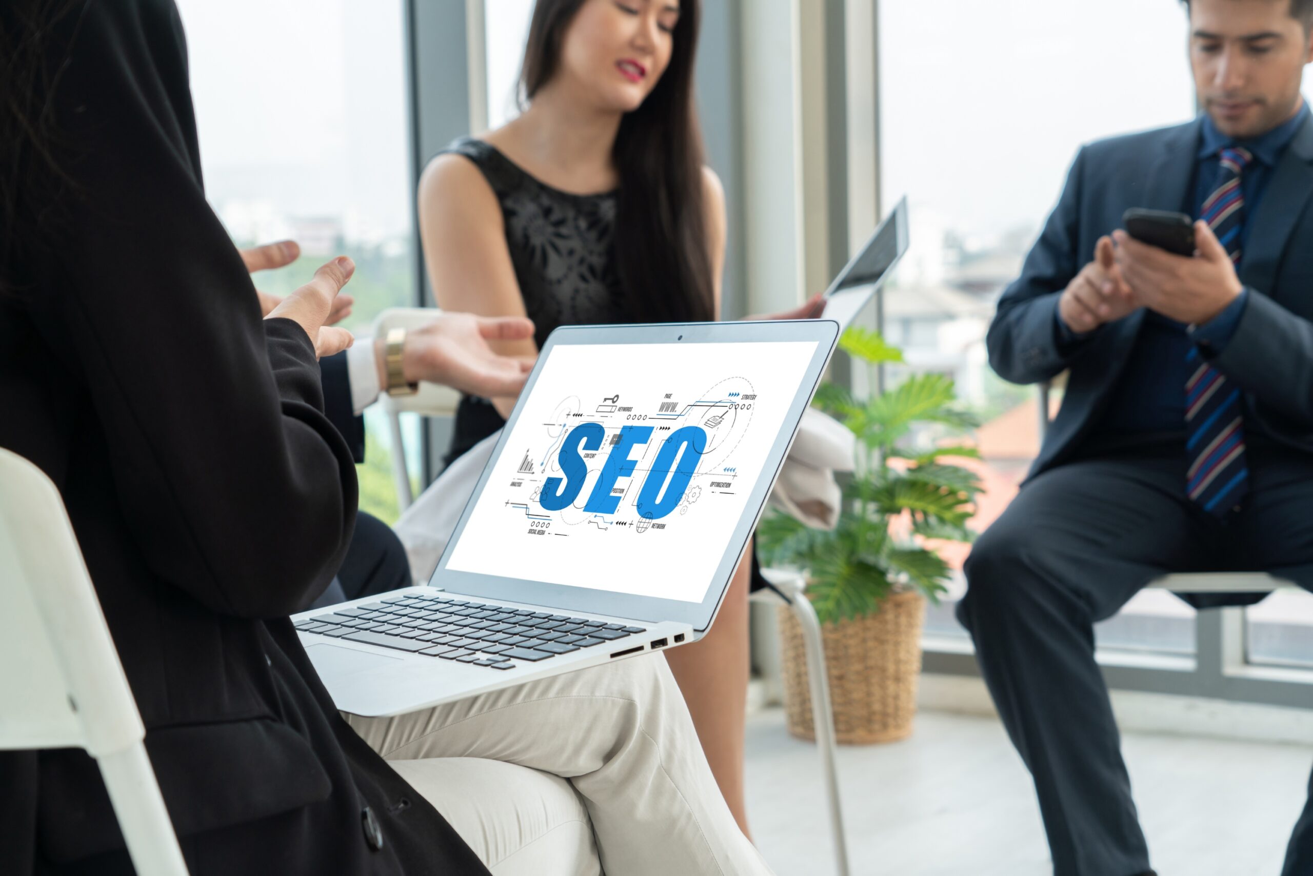SEO strategy meeting with professionals and laptop screen
