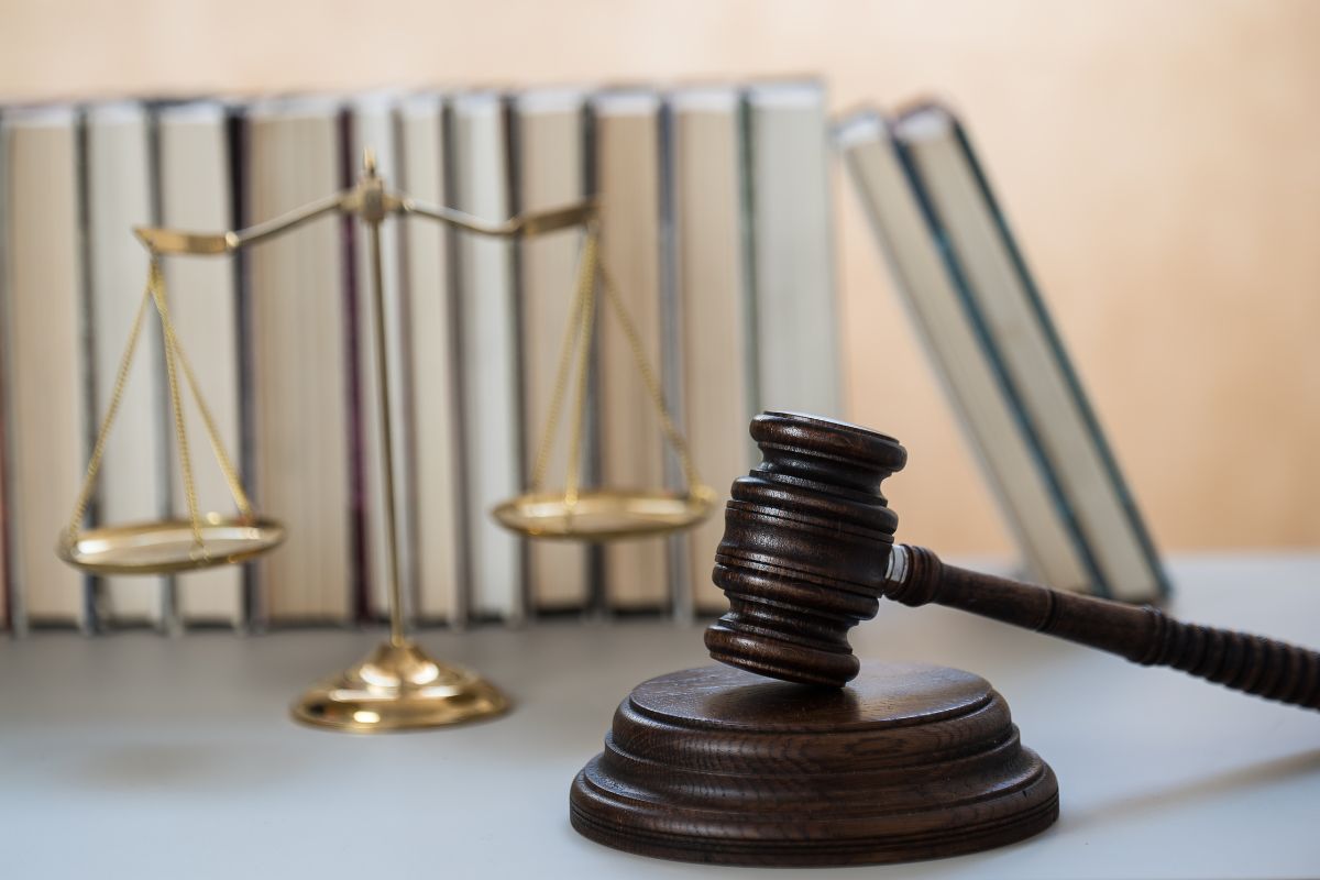 Judge gavel and legal scales with law books background